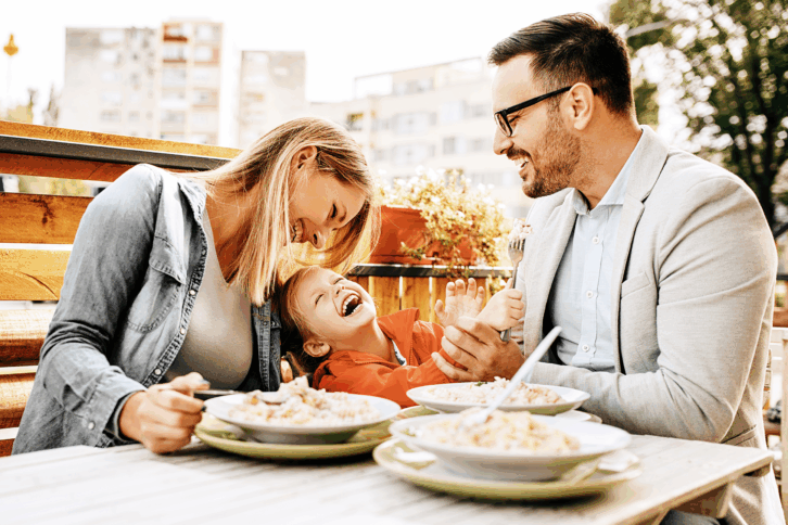 Happy family having a meal outside at a restaurant