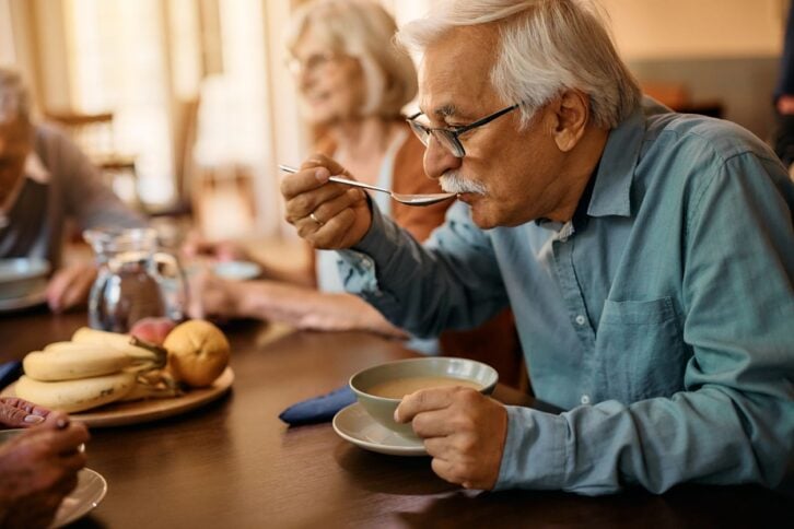 Senior man eating soup from a bowl