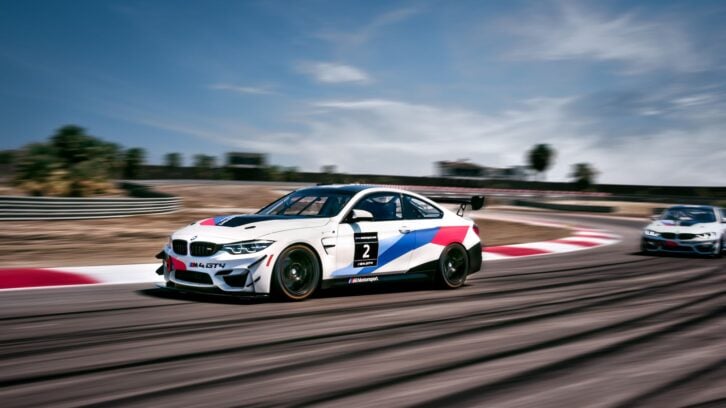 BMW M4 GT4 race car coming out of a corner on the track