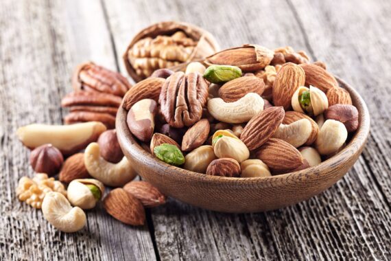Mix of nuts in a wooden plate on a rustic table