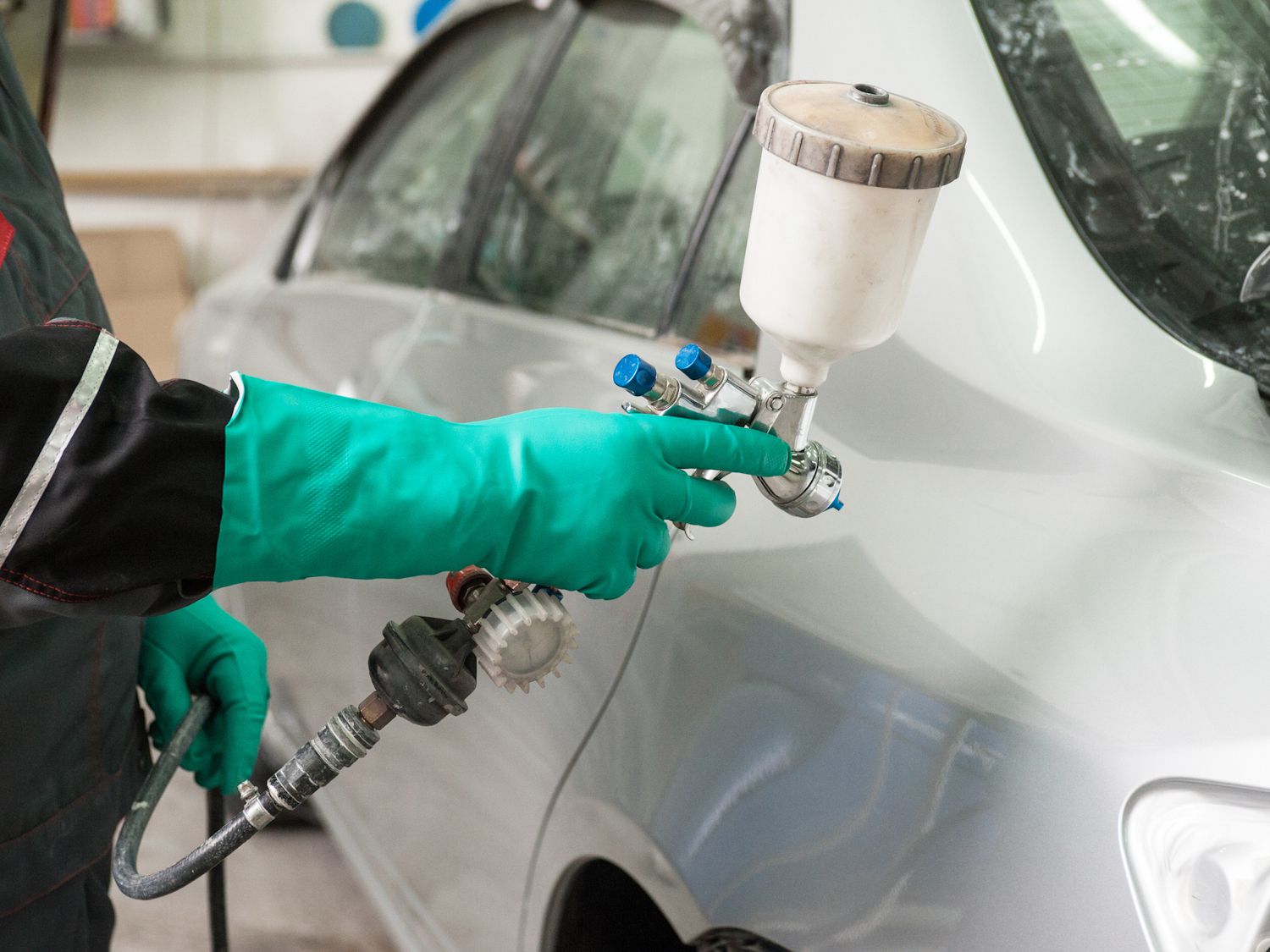 spray gun with paint for painting a car
