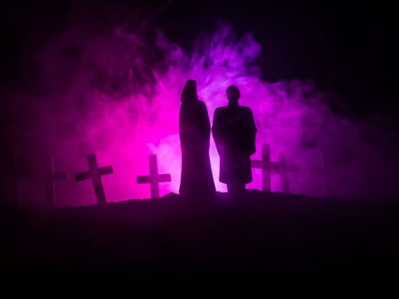 Horror Halloween concept. Scary zombie bride on a night cemetery.