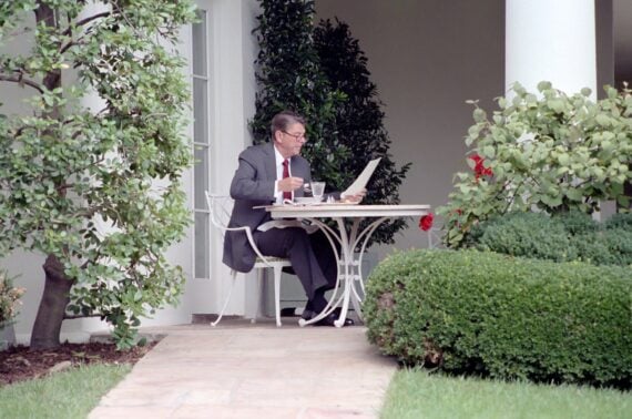 President Ronald Reagan Reading with Glasses on and Eating Lunch