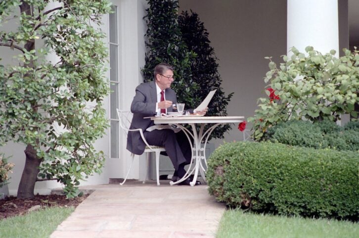 President Ronald Reagan Reading with Glasses on and Eating Lunch