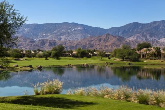 Golf course retirement home with a pond and hills and mountains