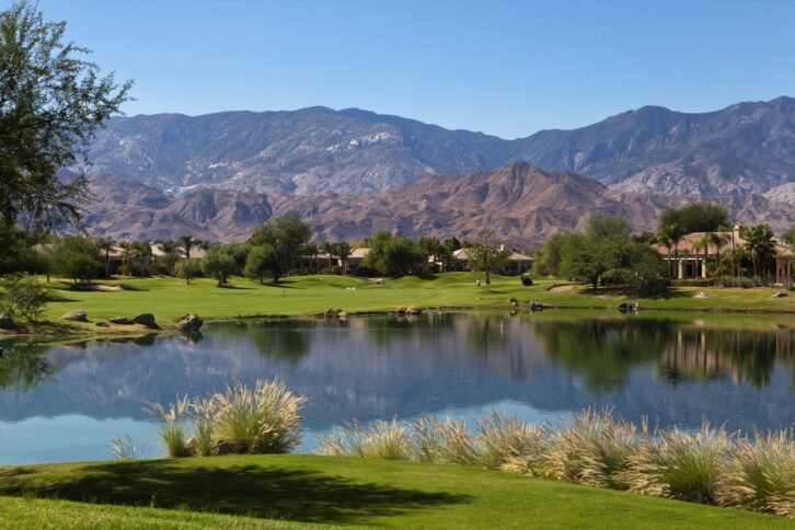 Golf course retirement home with a pond and hills and mountains