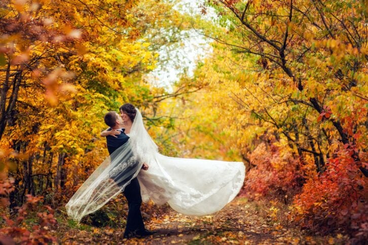 Couple taking wedding pictures in autumn