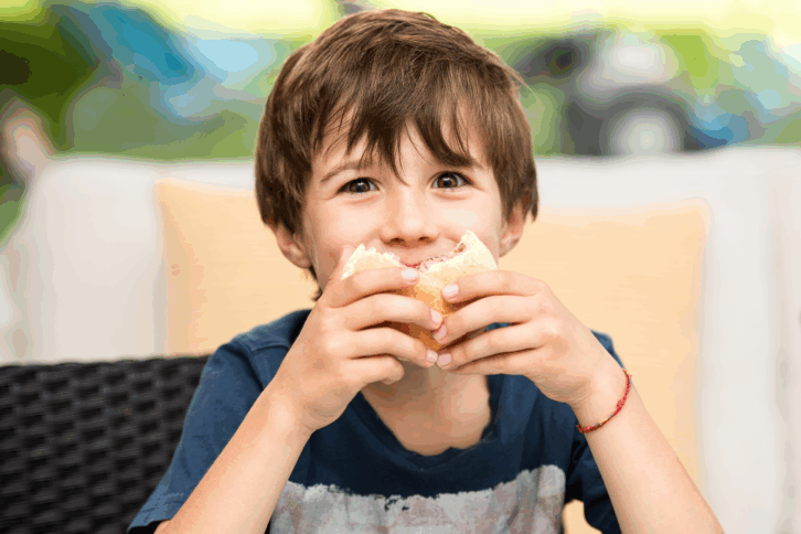 Young boy eating a hamburger