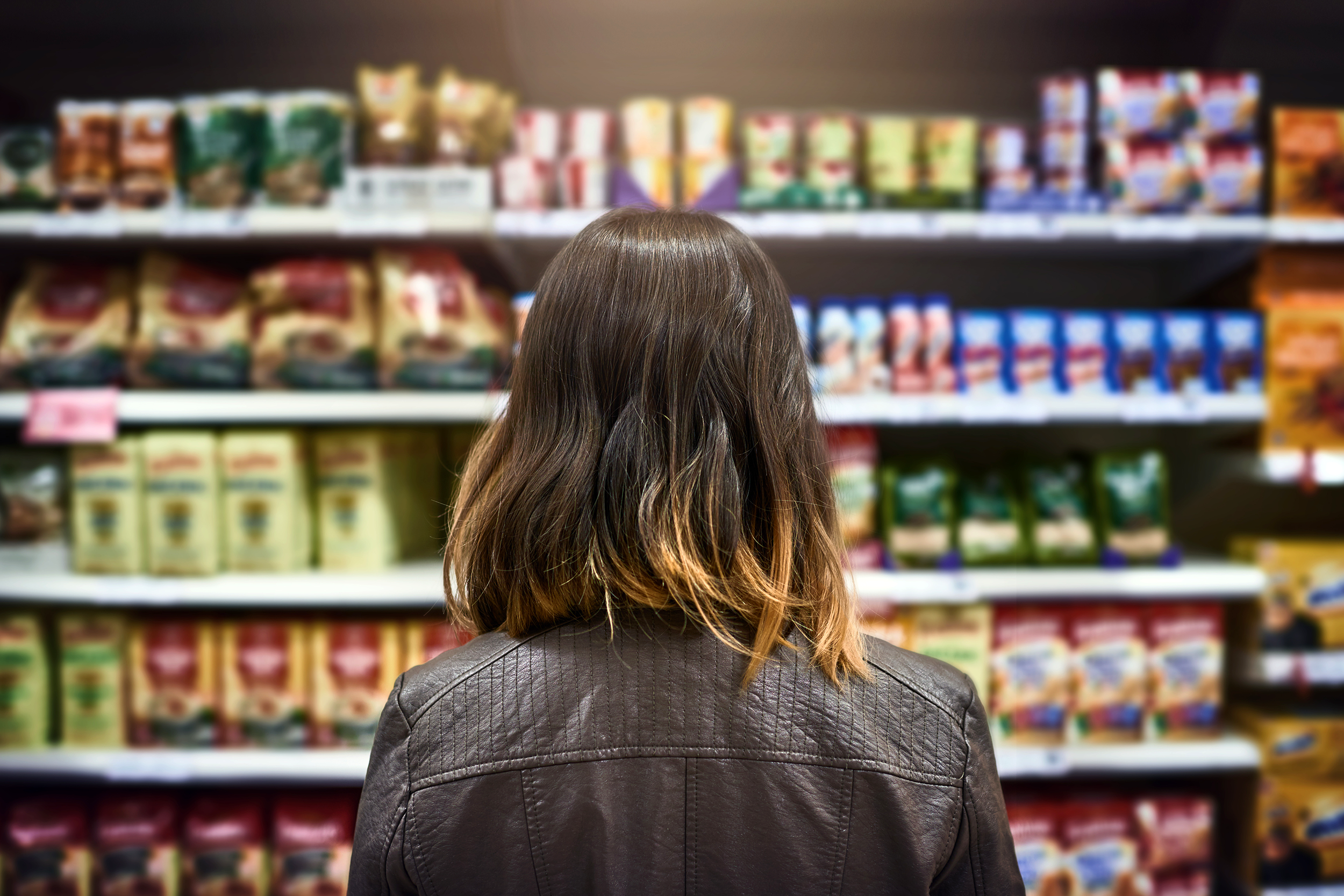 Woman staring at grocery shelves