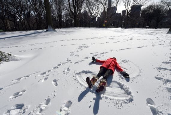 ara Jakeway with Chasing News makes a snow angel in the man-made snow in Central Park January 20, 2016 as part of Winter Jam NYC's Ultimate Snow Day.