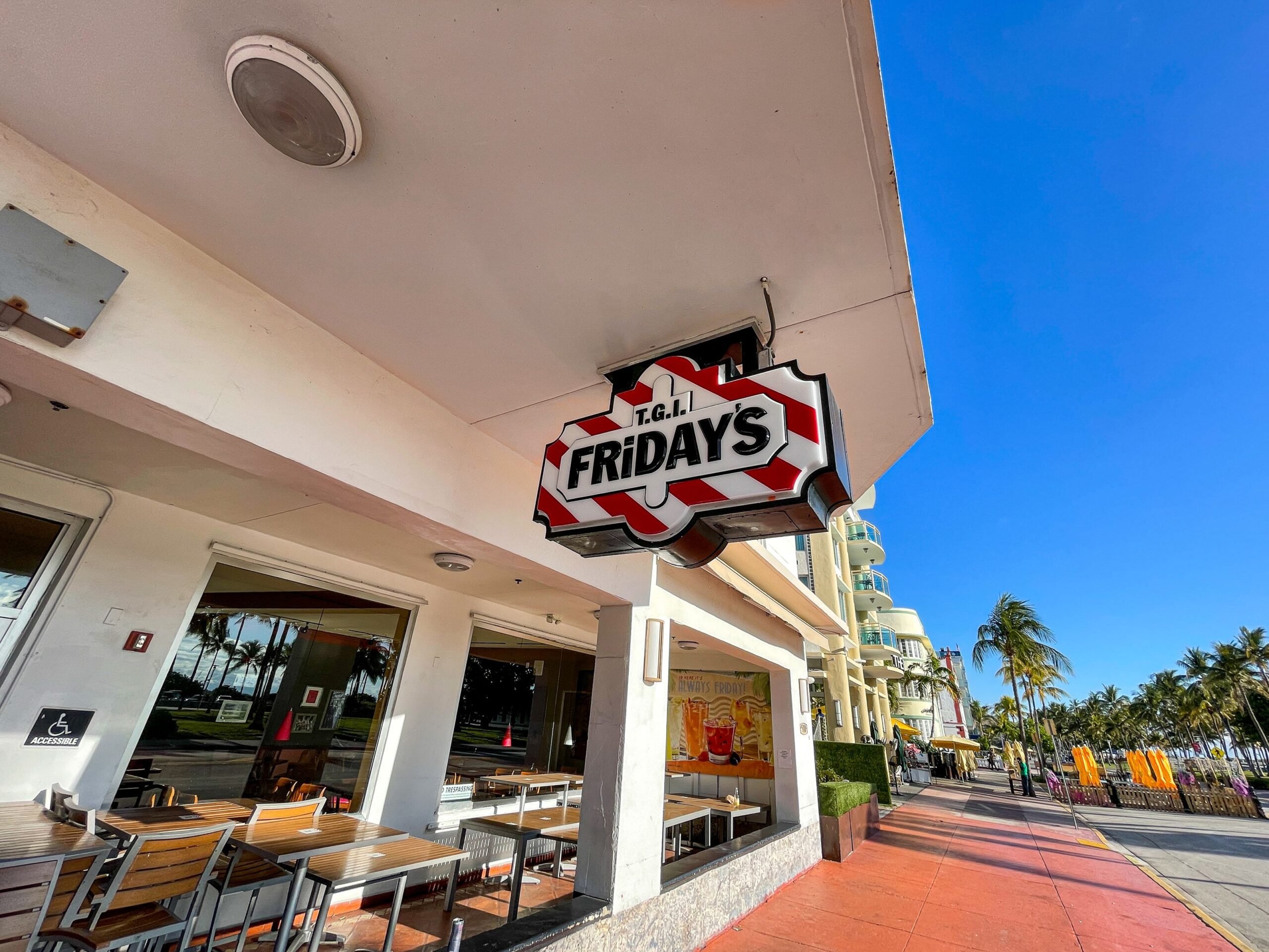 front eating area patio and sign of TGI Fridays, Miami Beach, Florida with beach and road in the background