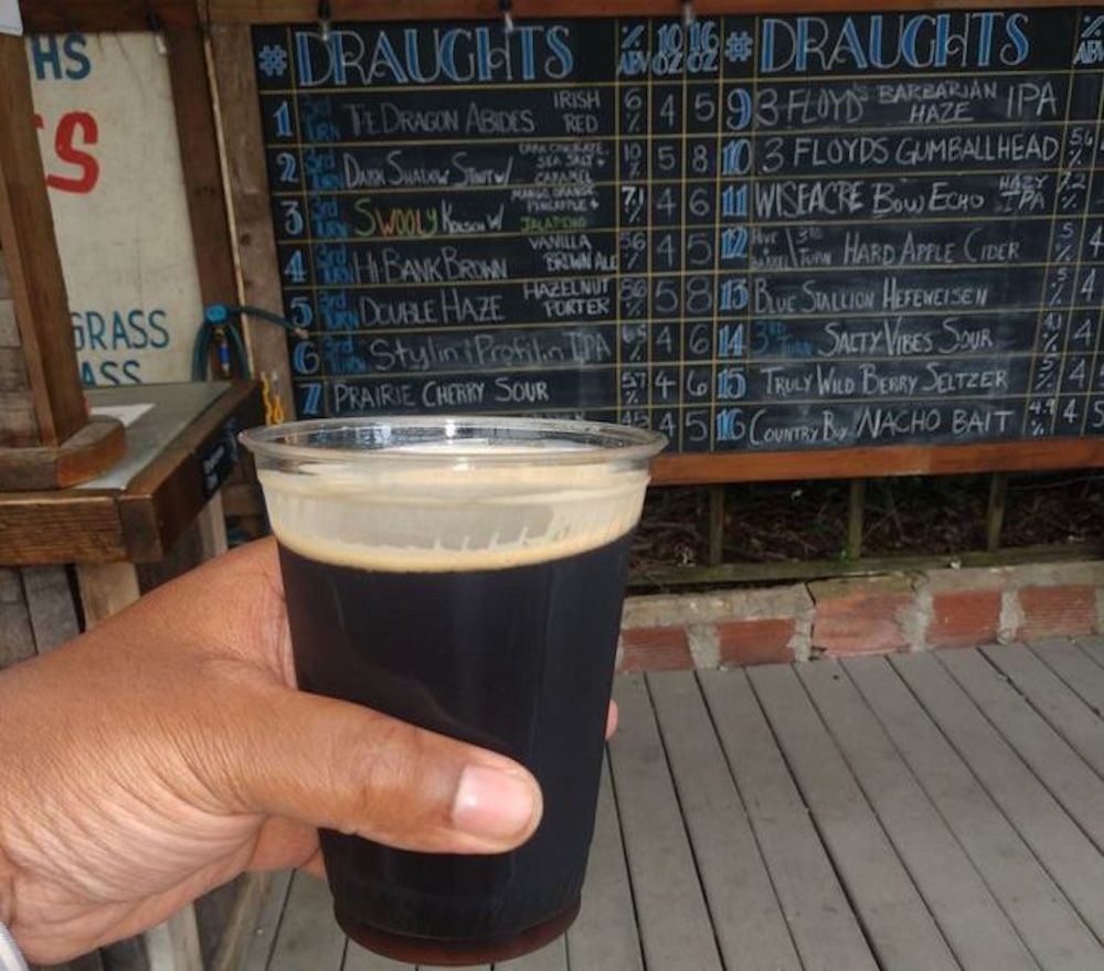 a hand holding a beer