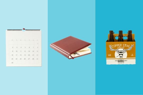 Three gift items on tri-toned blue hues, a wall calendar, a brown leather journal, and a six pack of Copper Stag beer