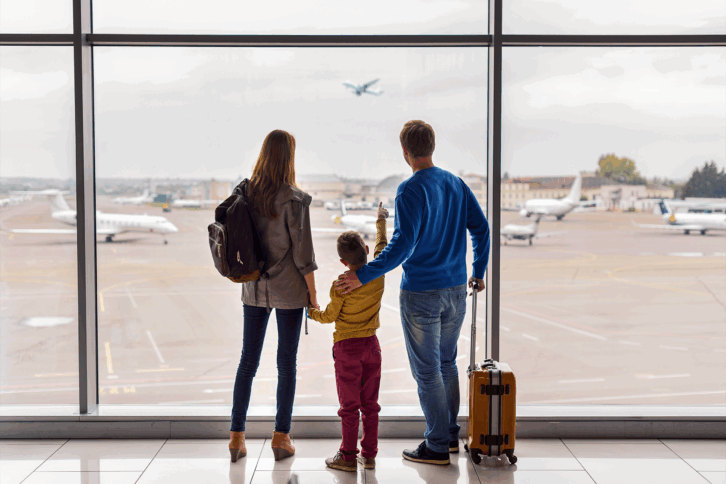 Family looking out window at airport