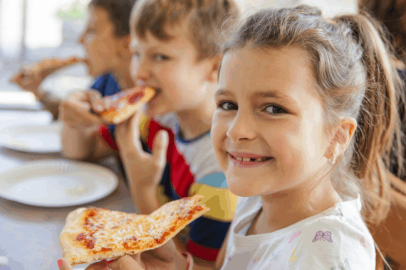Young children eating pizza in a restaurant