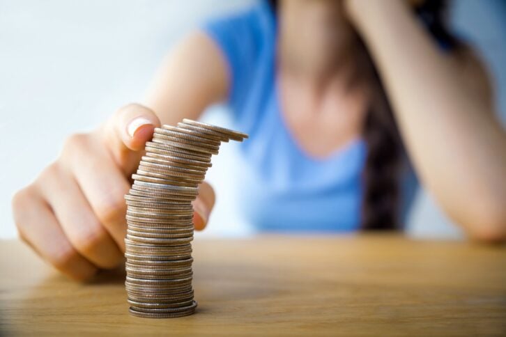Closeup of stack of coins with woman in the background