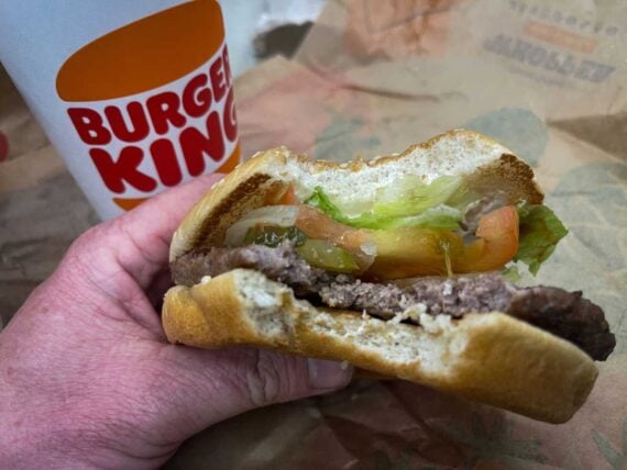 n this photo illustration, a man eats a Whopper Meal at branch of the fast food restaurant Burger King, on March 19, 2023 in Fleet, England.