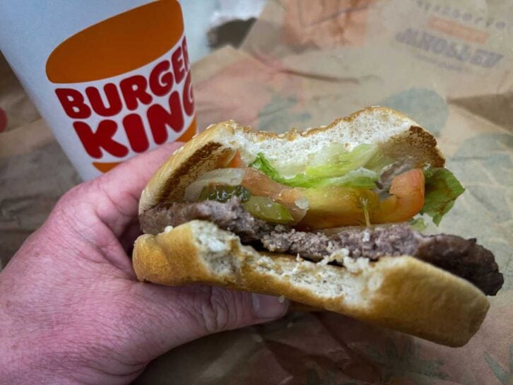 n this photo illustration, a man eats a Whopper Meal at branch of the fast food restaurant Burger King, on March 19, 2023 in Fleet, England.