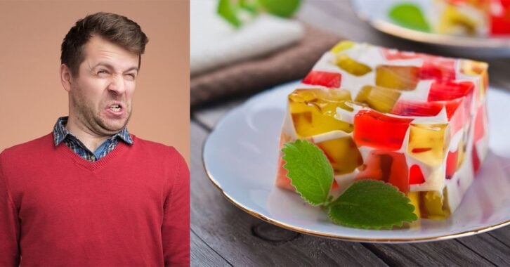 A man with a grossed out face looking at a picture of a jello dessert.