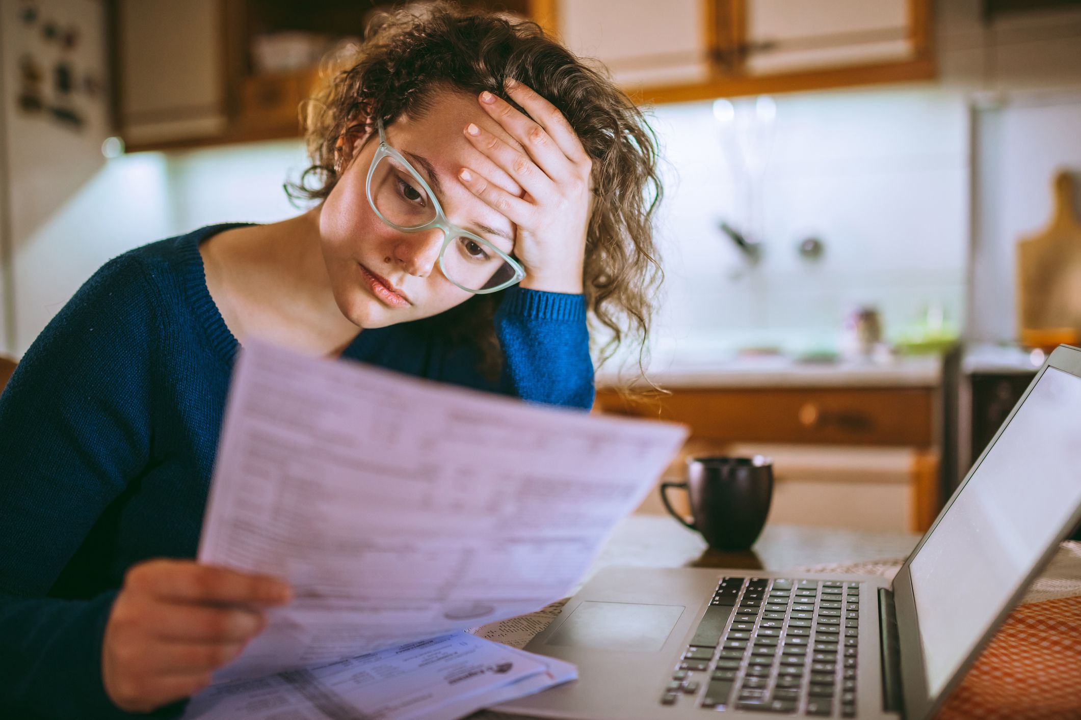 woman reading her bill papers, looking stressed