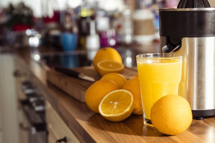 juicer making orange juice in kitchen