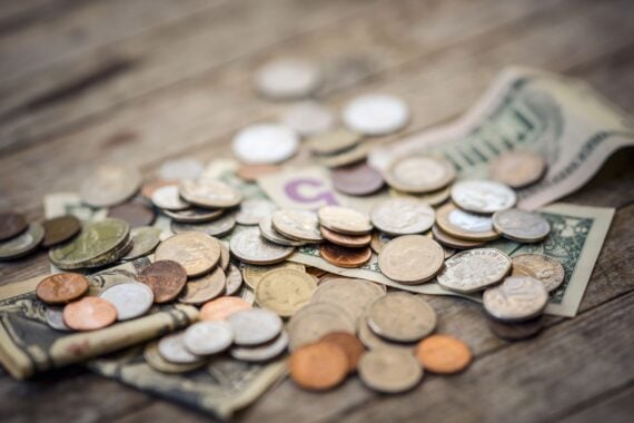 American banknotes and coins on wooden surface