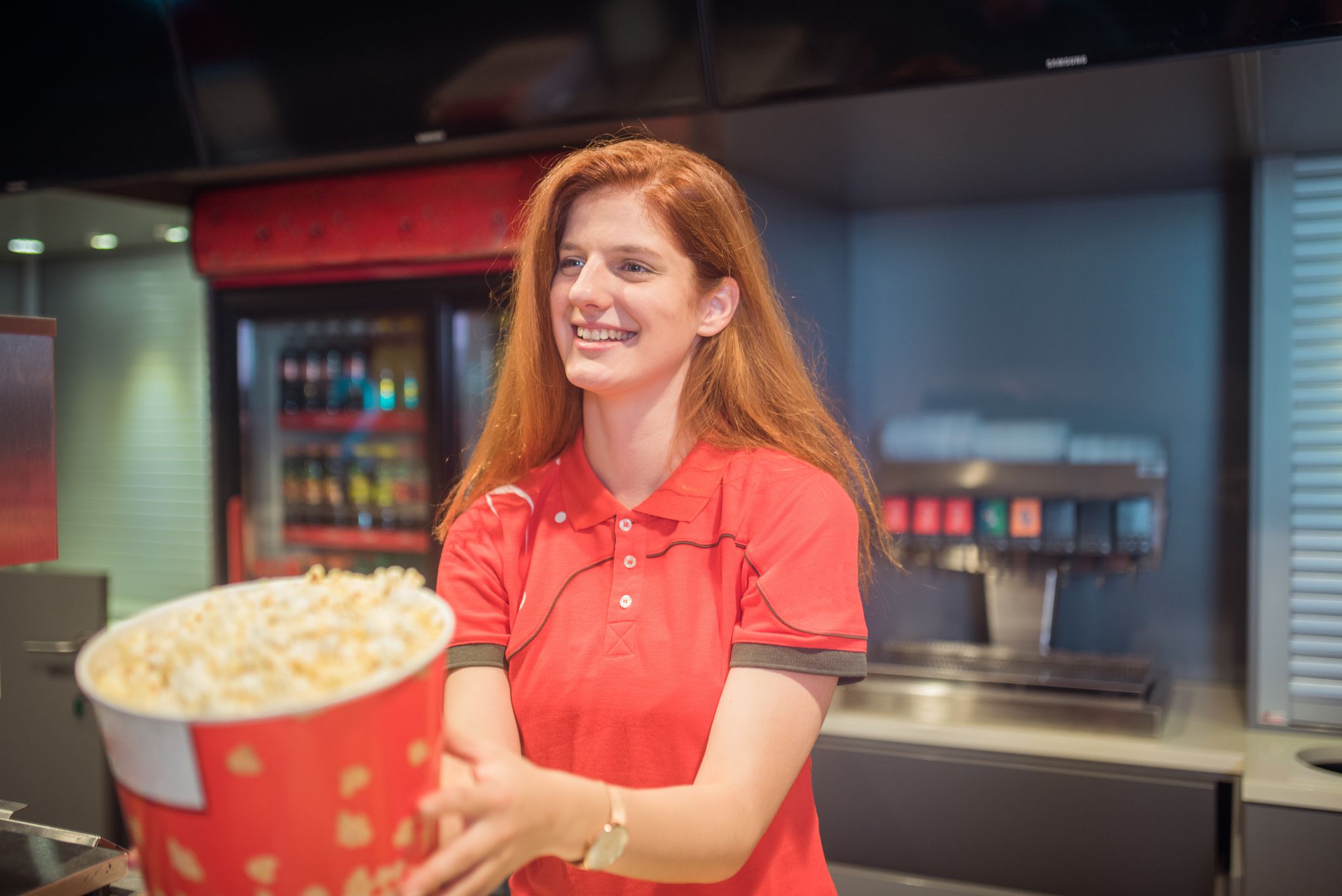 Young happy woman holding a box of popcorn