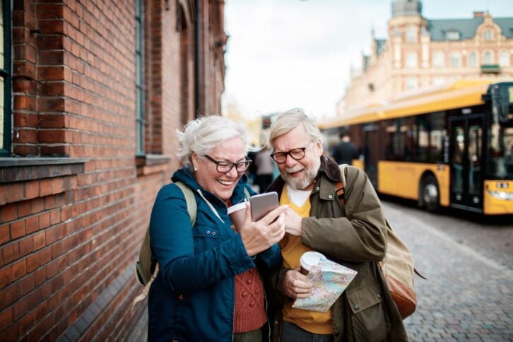 senior couple looking at phone in European city