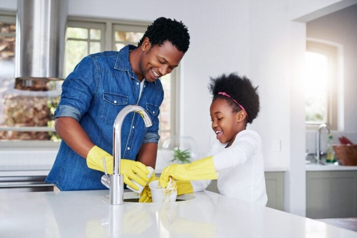 man and girl cleaning kitchen