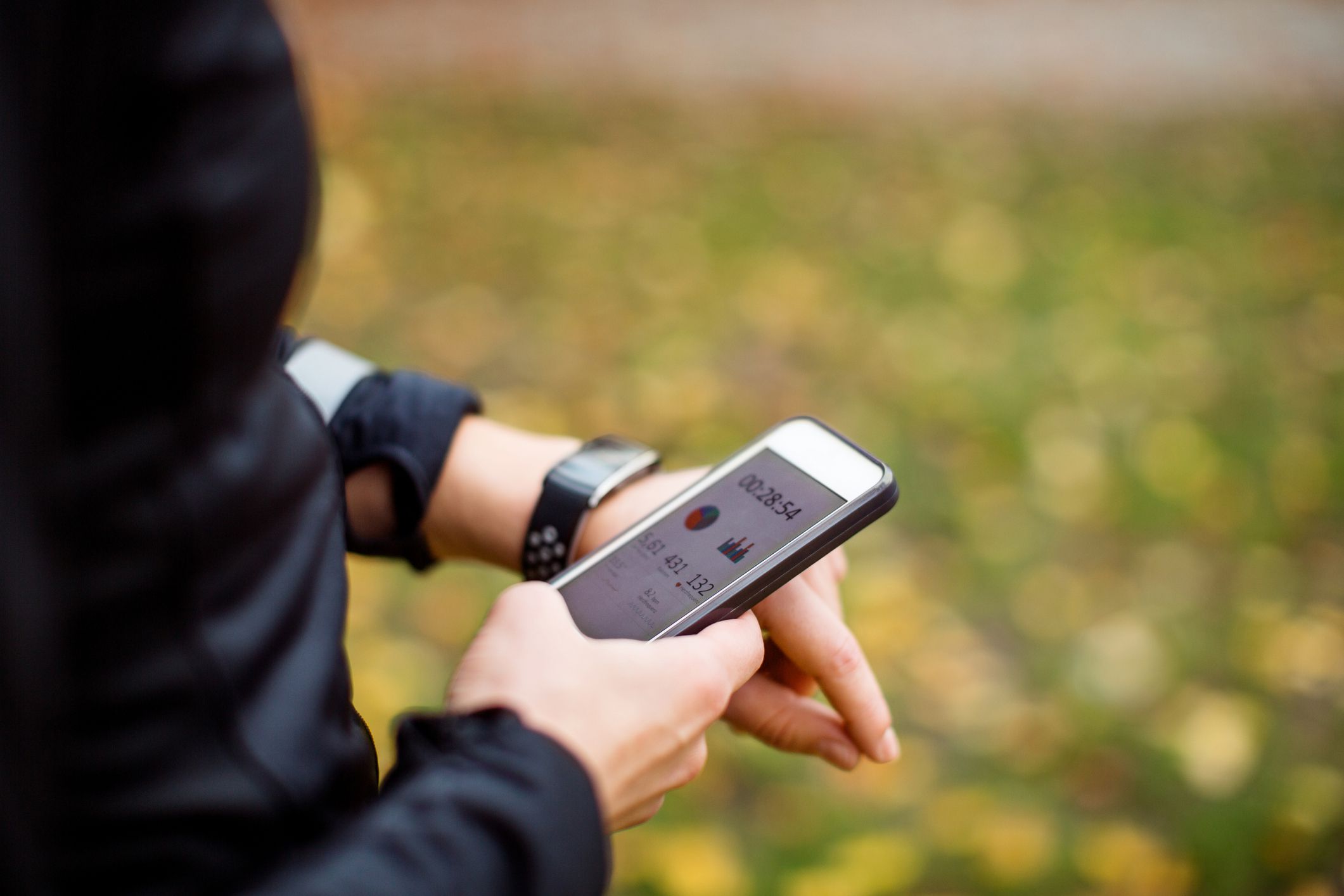 close up of a urban runner using sporty smart watch and smartphone app for training