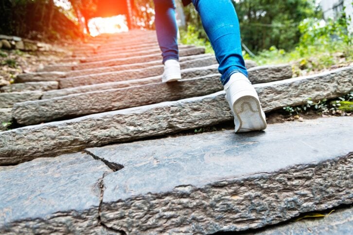 young woman walking up the stone stairs