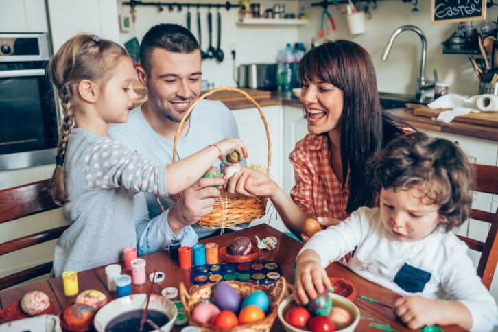 Happy family and their Easter Basket with Colored Eggs