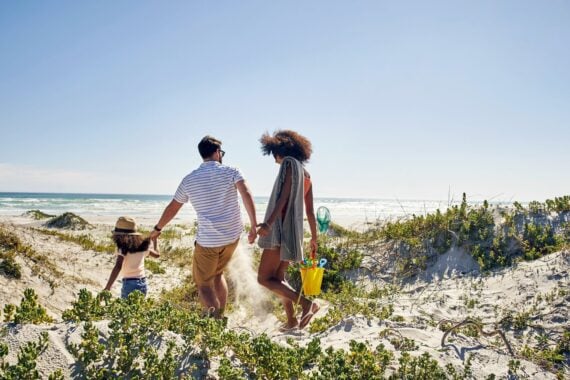 family walking towards beach