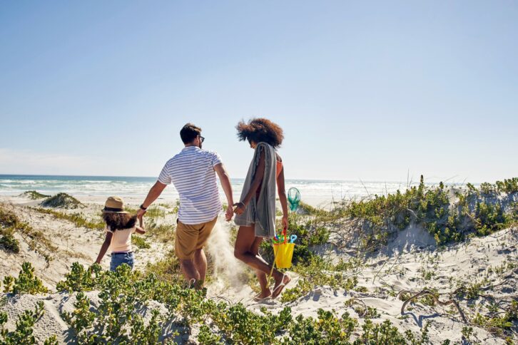 family walking towards beach