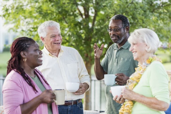 two older couples hanging out on patio, drinking coffee
