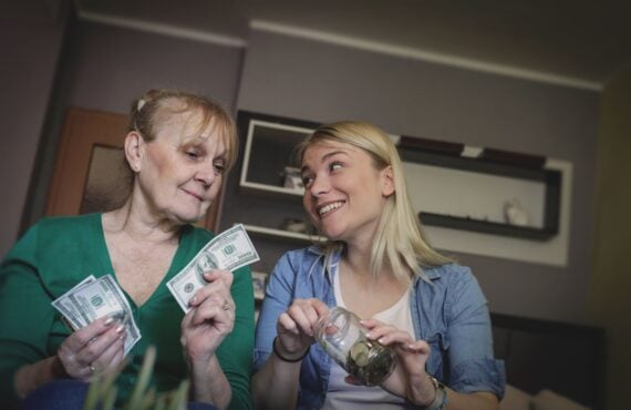 Senior mother with daughter holding money.