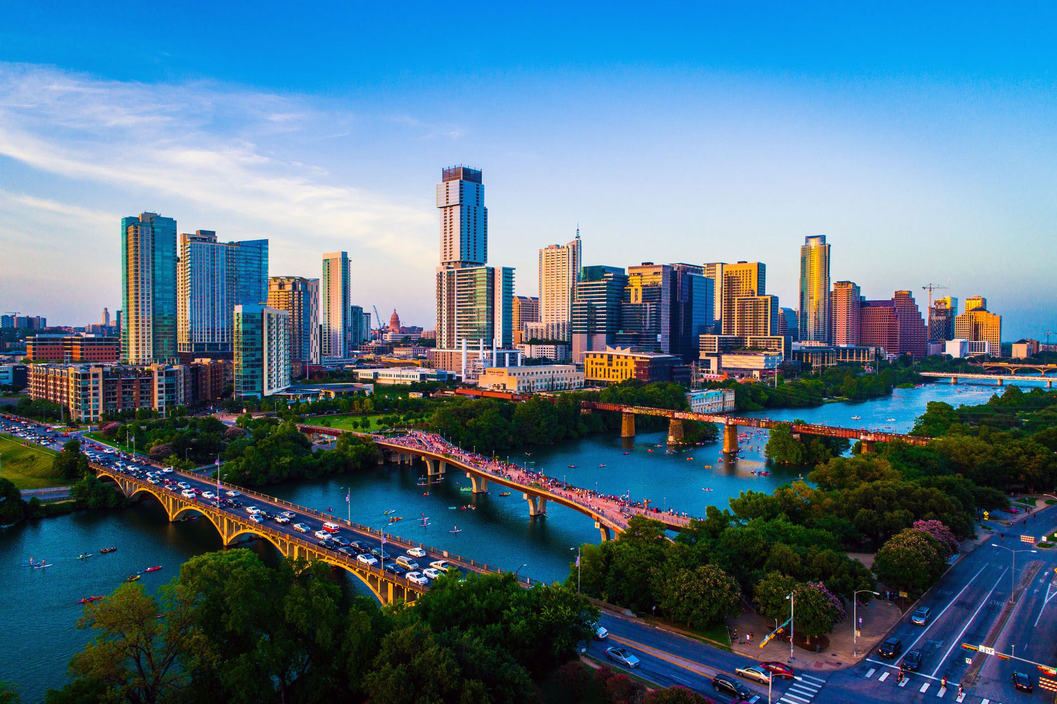 gorgeous afternoon sunset with a clear sky and the entire downtown skyline cityscape across from town lake or lady bird lake in austin texas 2019 kayakers and lake filled with crowds of people on july 4th
