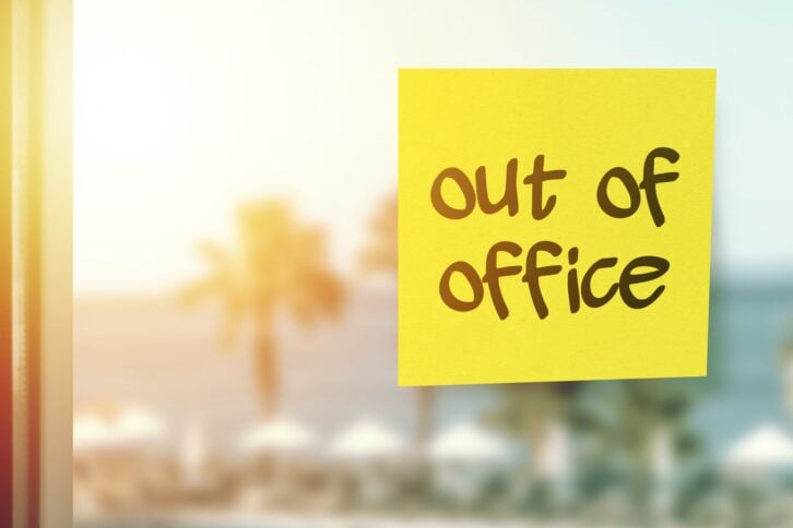 Out of office sticky note paper on the hotel window vacation concept