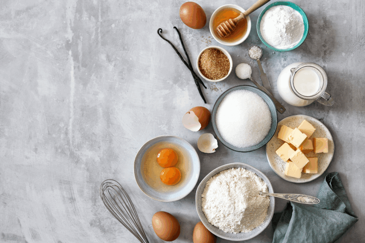 various baking ingredients including flour, butter, eggs, milk