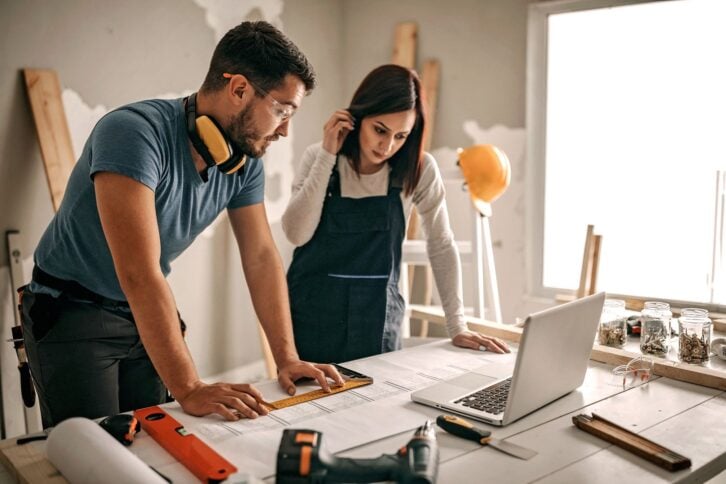 Woman analyzing blueprint for her new home interior