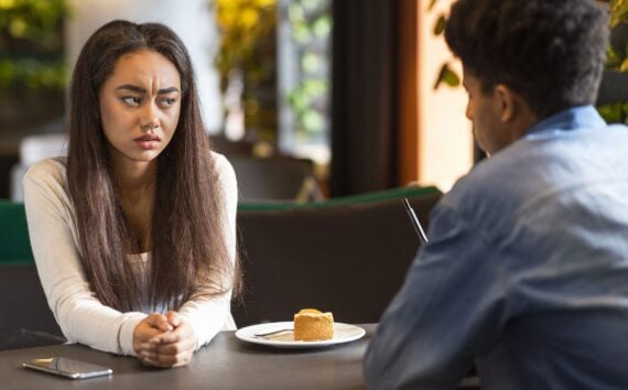 Relationships problem. Teen mixed race couple arguing, sitting at cafe
