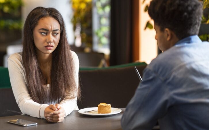 Relationships problem. Teen mixed race couple arguing, sitting at cafe