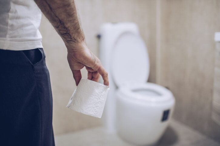 Man suffers from diarrhea holds toilet paper roll
