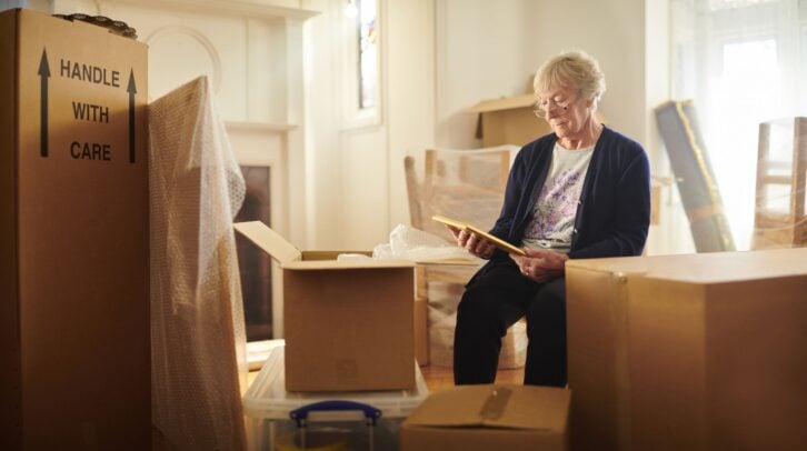 senior woman looks through some memories just before the house move begins
