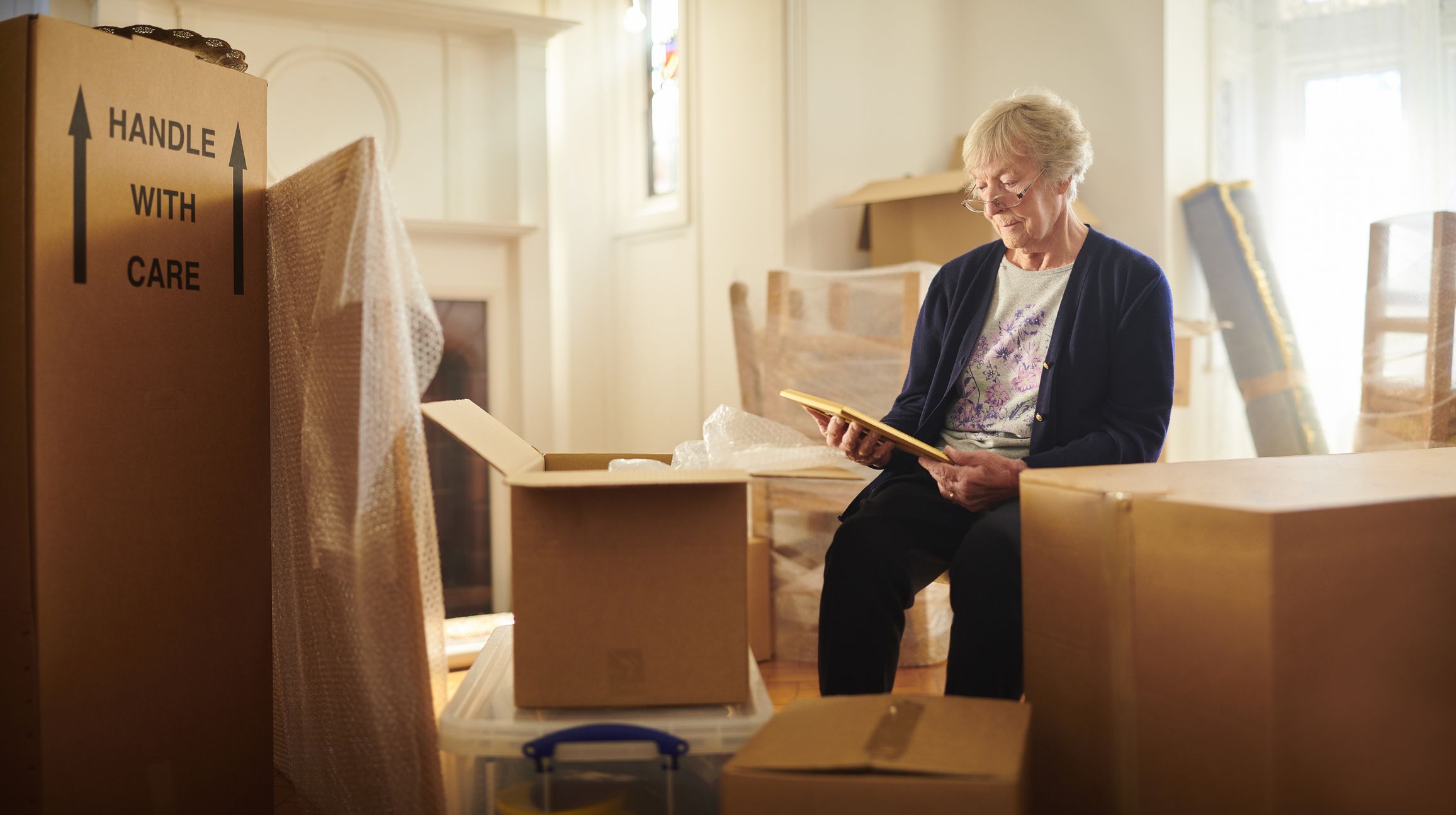 senior woman looks through some memories just before the house move begins