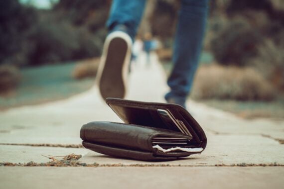 Person walking away from a wallet on the ground