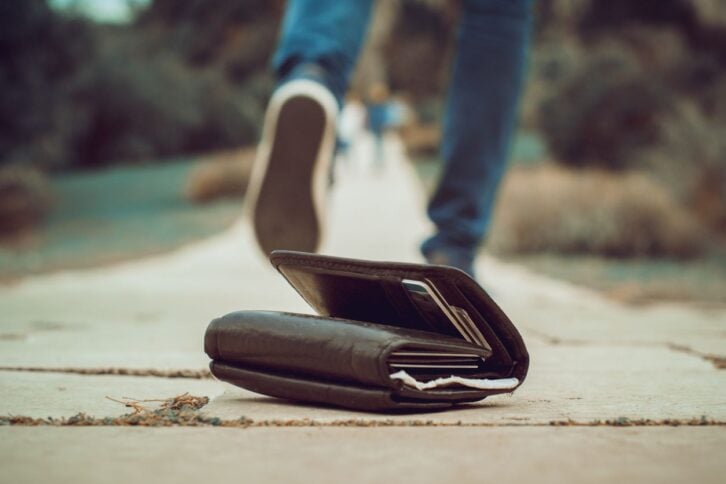 Person walking away from a wallet on the ground