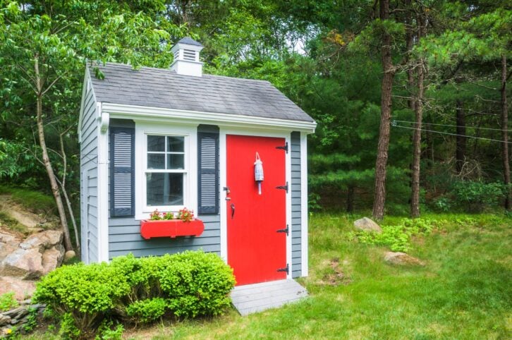 A small shed with a ramp holds, lawnmowers, snow throwers and tools for yard maintenance.