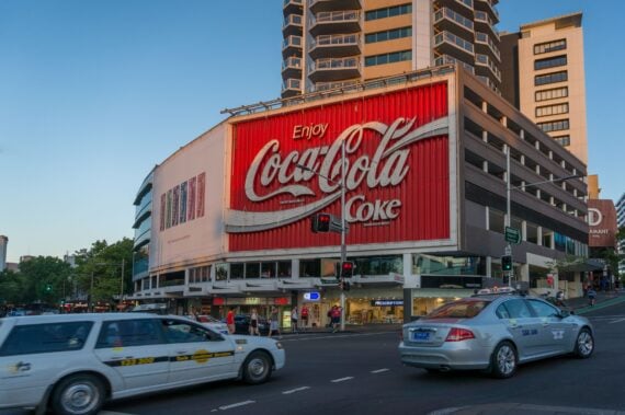 Sydney, Australia - November 12, 2014: Famous Coca Cola advertisement on a building in Kings Cross suburb of Sydney with evening traffic