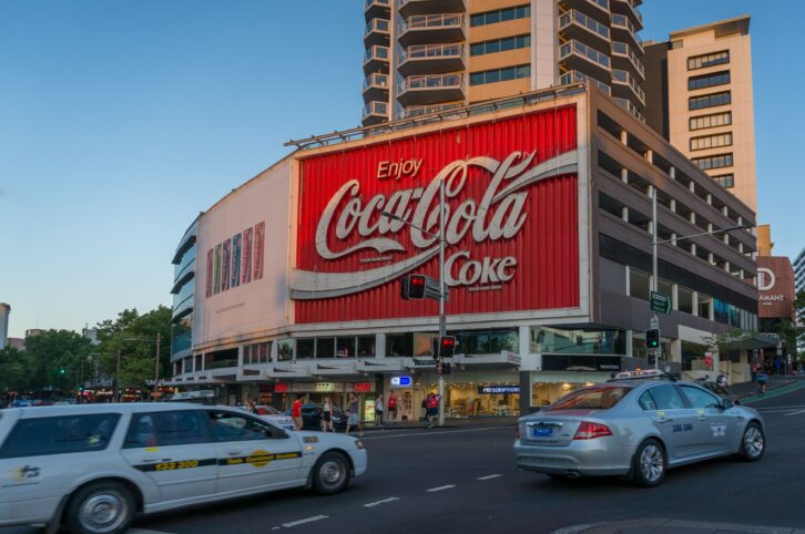 Sydney, Australia - November 12, 2014: Famous Coca Cola advertisement on a building in Kings Cross suburb of Sydney with evening traffic
